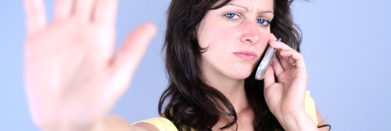 Kvinde taler i telefon og viser stop med hånden